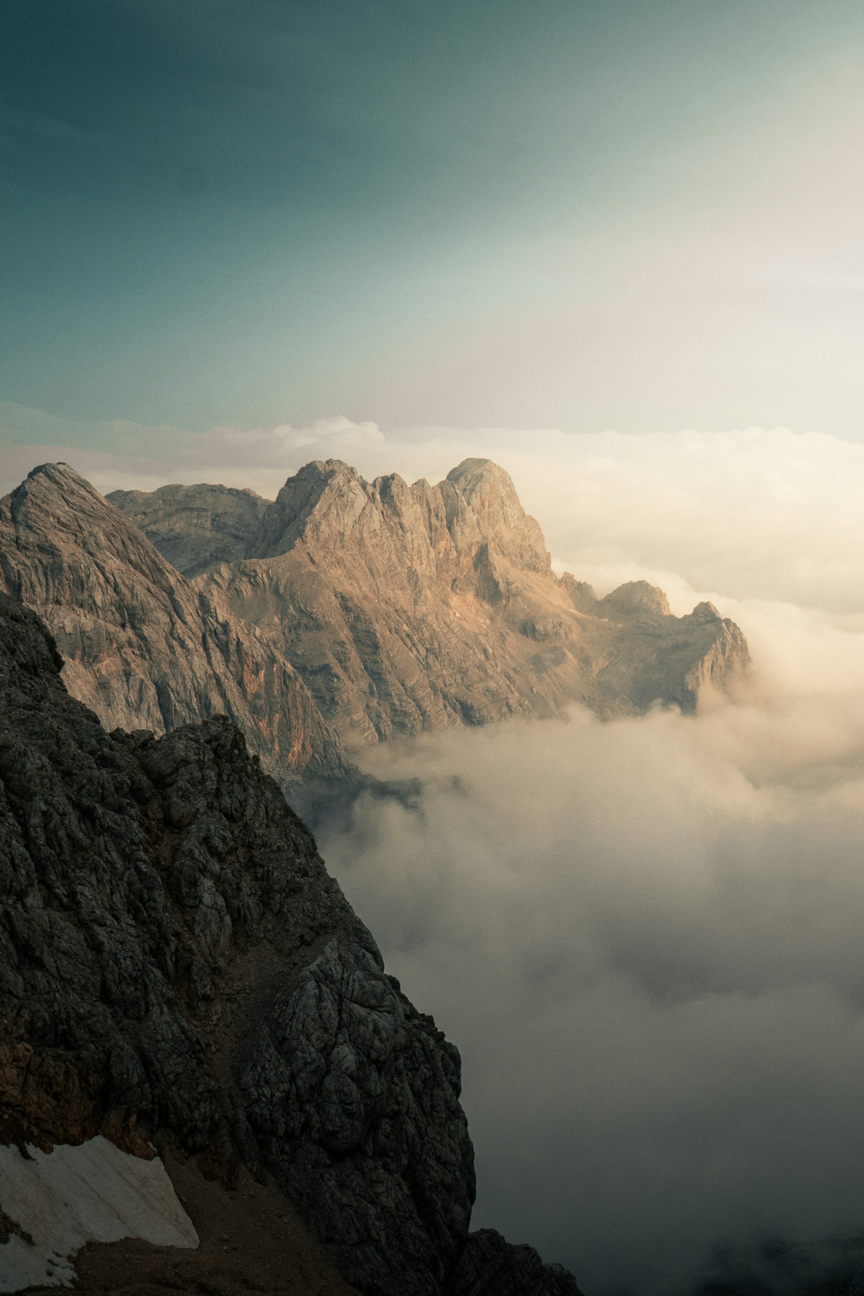 Rugged mountain peaks rising above a thick layer of low clouds